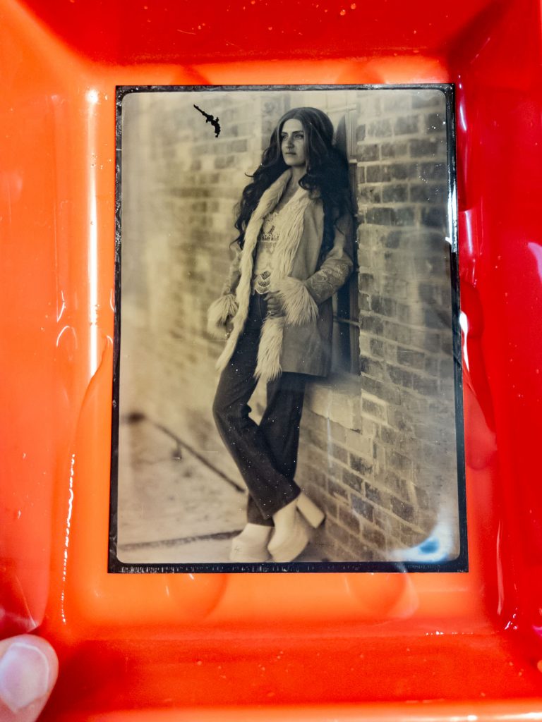 washing a tintype of a woman in a warm coat
