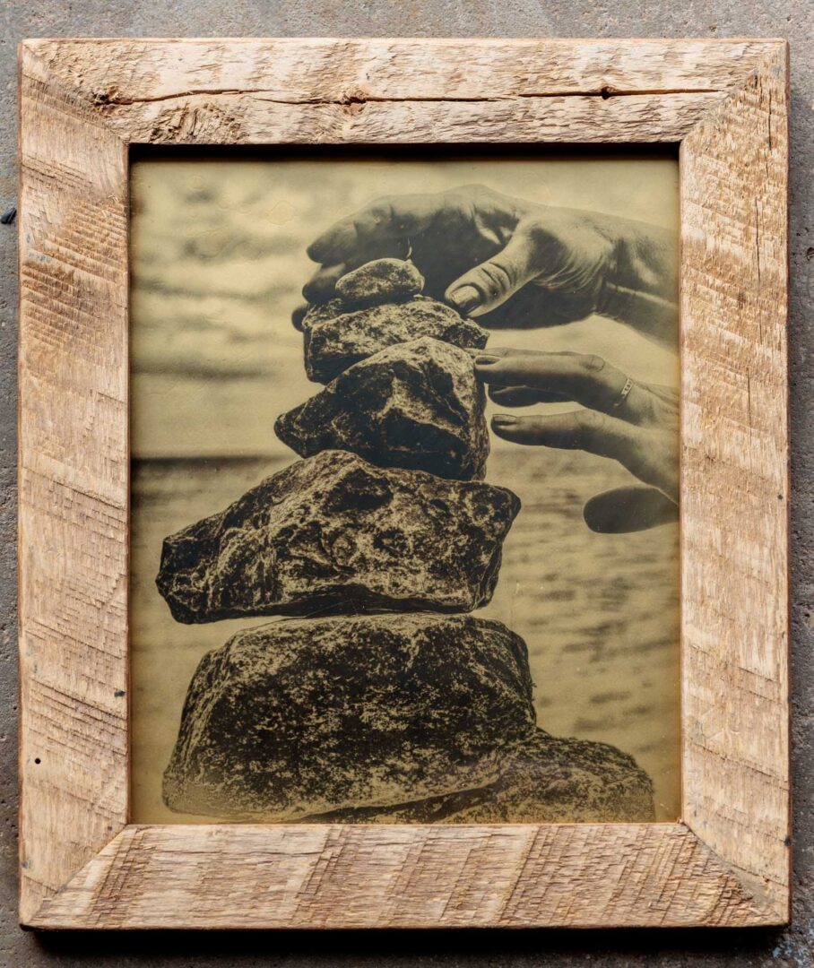 Silver Collodion glass image of hands stacking rocks
