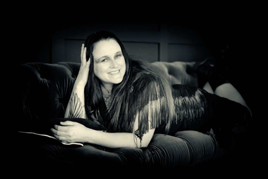 black and white portrait of woman on on an antique couch